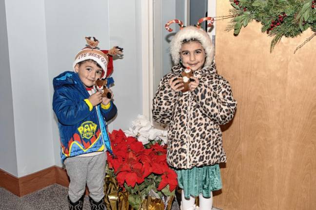 Anthony Zummo, 4, and Amalia Zummo, 6, with toys from Santa.