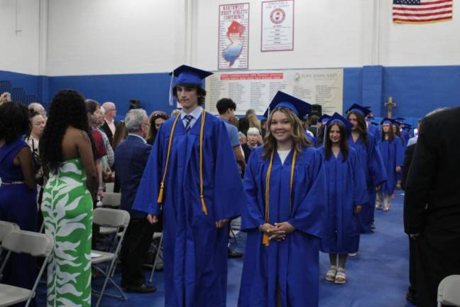 Graduates march down the aisle to their seats in the gym.