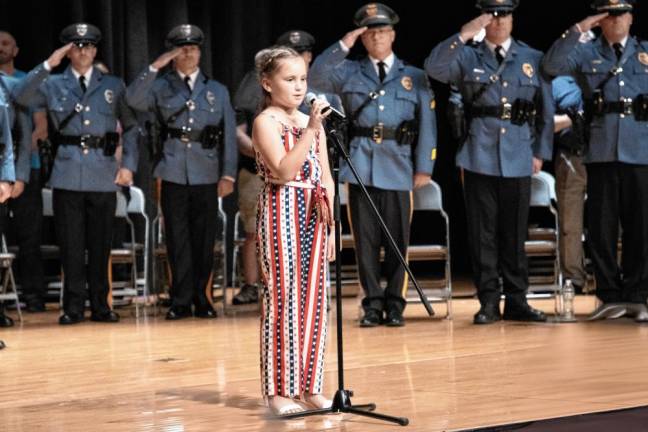 Piper McCarrick, 9, daughter of Chief Jeffrey McCarrick, sings the National Anthem.