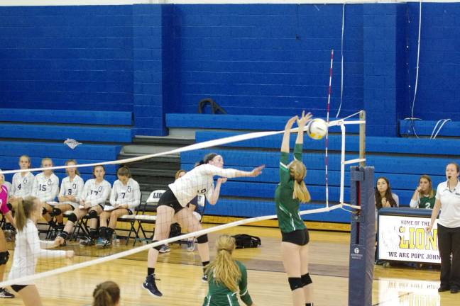 Pope John's Grace Parker (9) blasts the ball past a Montville opponent. Parker contributed one ace, fourteen kills, 0.5 blocks and ten digs.