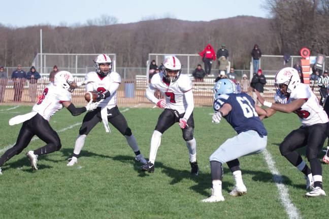 The Bergenfield Bears in the midst of a hand-off play while confronting a Sparta Spartan.