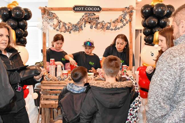 Emma Aguado and Vincent Volpe, both of Sparta, and Alisha Santos of Andover Township sell hot cocoa.