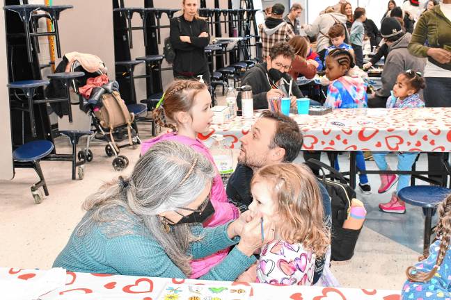 Children have their faces painted.