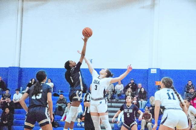 Pope John's Mia Washington and Immaculate Heart's Olivia Valente reach for the ball during the tip-off to start the game.