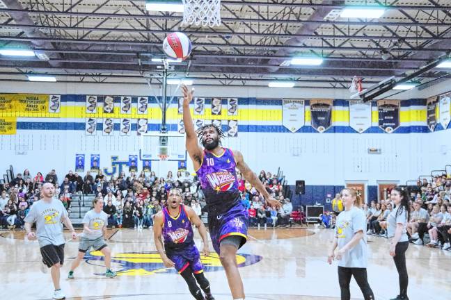 Harlem Wizards player Deven ‘Just Do It’ Dorsett (10) tosses the ball toward the hoop.