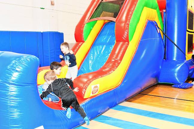 Children play on an inflatable slide at the Winter Carnival on Saturday, Feb. 1 at Sparta Middle School.