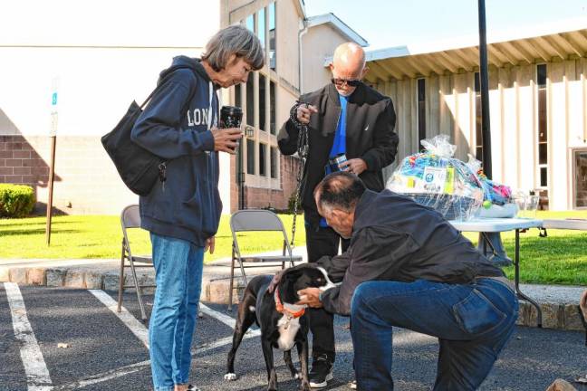 The Rev. Dr. Jack DiMatteo blesses a dog named Sug. (Photo by Maria Kovic)