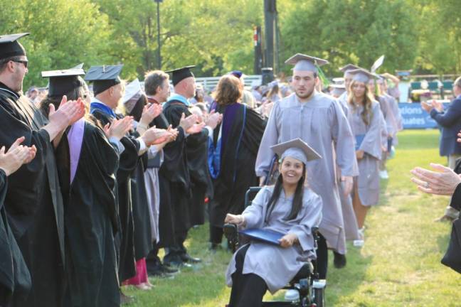 The audience applauds the graduates.