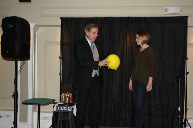 Sparta Avenue Stage owner Joe Garsetti does a magic trick for audience member Nicole Garcia.