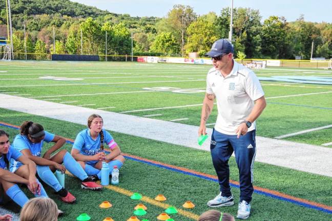 Head coach Daniel Trappe discusses strategy with the Spartans during a break.