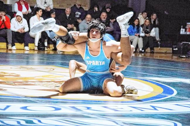 Sparta's Sean Brown looks up after upending Pope John's Daniel Arroyo in the 144-pound match. Brown won by decision (4-3).