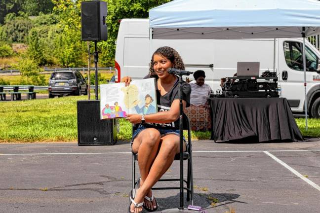 H3AL volunteer Olivia Webster reads a children’s book about the Juneteenth holiday. (Photo provided)