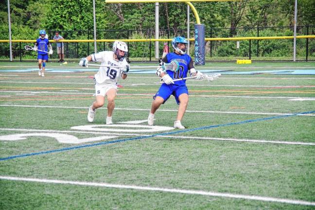 Cole Friedmanis of West Morris is in possession of the ball as Sparta's Greg Peters reaches in with his crosse to interfere.