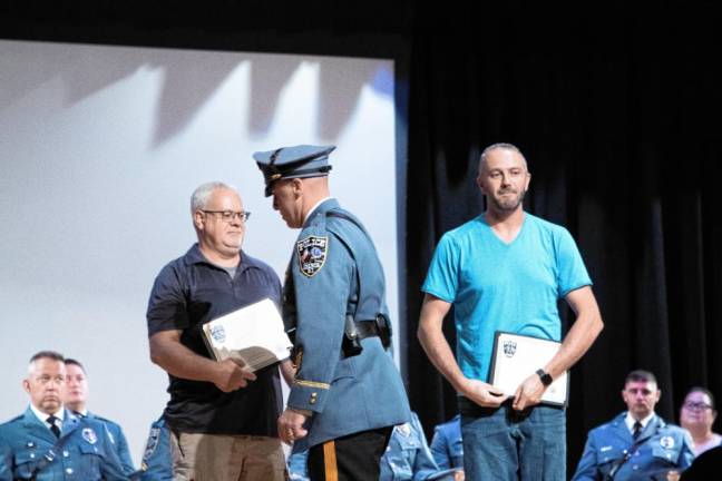 Chief Jeffrey McCarrick commends dispatchers Scot Sorensen and Dan Koteras for their handling of hundreds of calls after the earthquake in April.