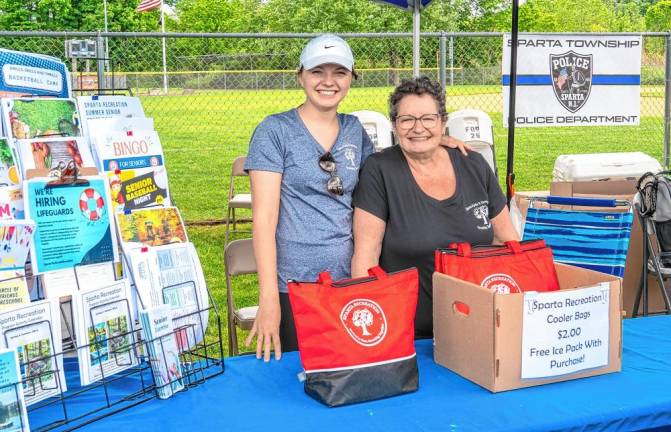 Janice Williams and Emily Fisher hand out cooler bags at the township Parks &amp; Recreation table. (Photo by Nancy Madacsi)