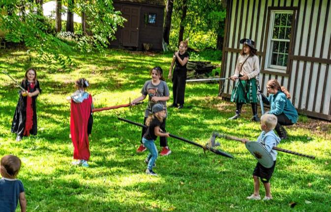 Children try sword fighting.