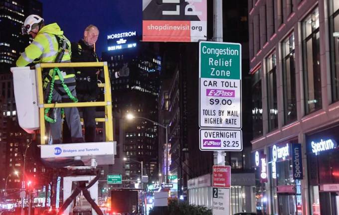 MTA chairman Janno Leiber unveils a congestion pricing sign at midnight on Sunday, Jan. 5 on the first day of the toll.