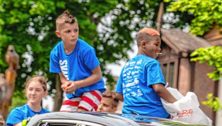 Jules Reid, Blake Pituch, Ben Parnell and Quinn Miles of the Lake Mohawk Ski Hawks ride in the parade.