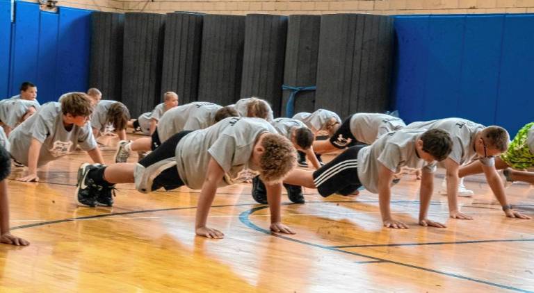 Participants in the Sparta Township Police Department’s Junior Police Academy do push-ups.