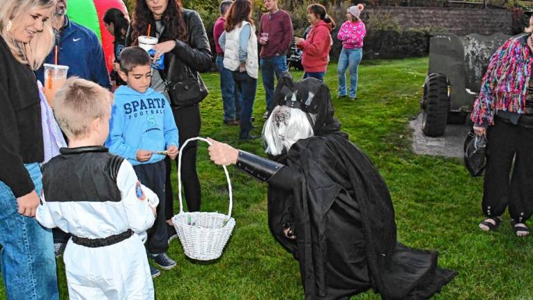 A costumed creature offers treats to children at the Hanging with Heroes event Friday, Oct. 11 in Sparta. (Photo by Maria Kovic)